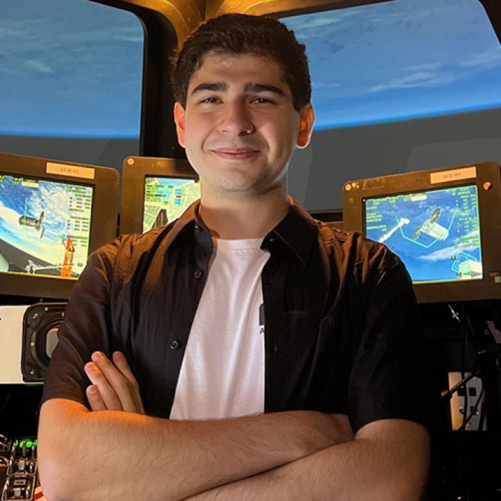UC Davis student standing in front of a console