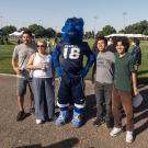 Four people pose with alongside Gunrock for a photo at Hutchinson Field.