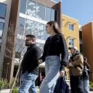 A group of seven students and parents walk in front of residence hall on Aggie Day 2024.